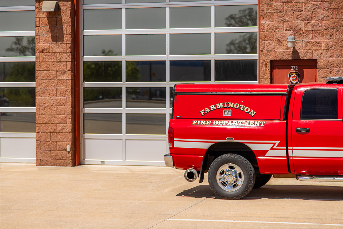 Farmington Fire Station with large bay doors and parked car