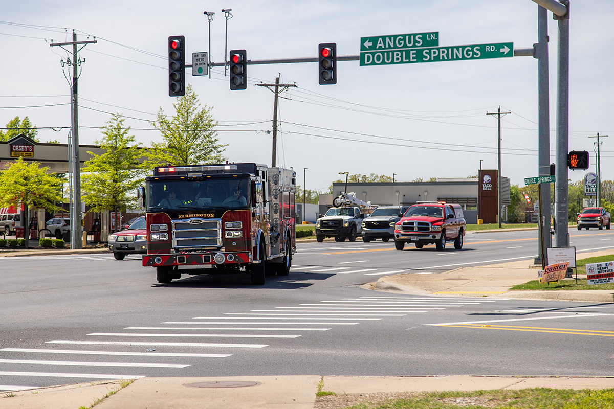 Firetruck of Farmington Fire Department is passing through an intersection with traffic lights