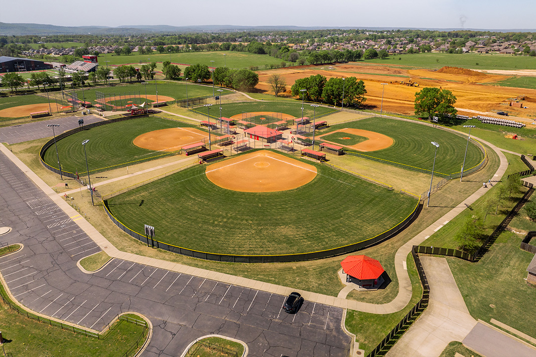  Aerial view of a Farmington symmetrical baseball quad complex with four diamonds, infields, parking lots